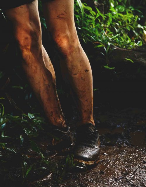 Muddy Hiker legs in sneakers on the way to Mt Qua Qua on Caribbean Island Grenada